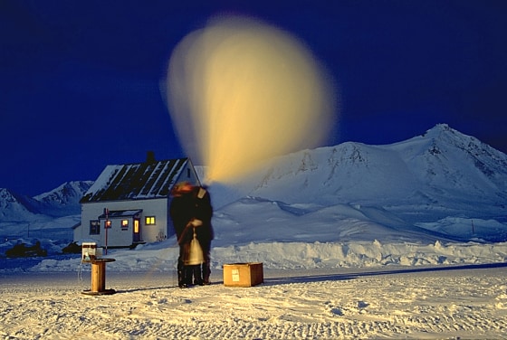 Researchers in Spitzbergen, Norway, prepare to launch a balloon that's hooked up to an ozonesonde, a device that measures ozone layer conditions. The low light created the blurred image of the balloon.