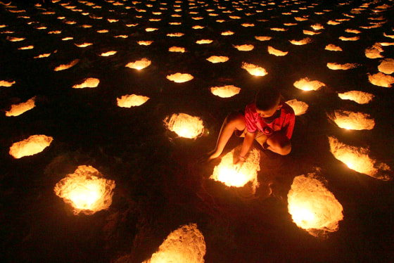 A young Thai lights candles during a vigil for tsunami victims on Thailand's Patong beach