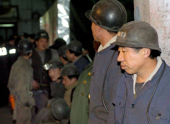 Chinese workers wait at the scene after a coal-mining accident in Fuxin city