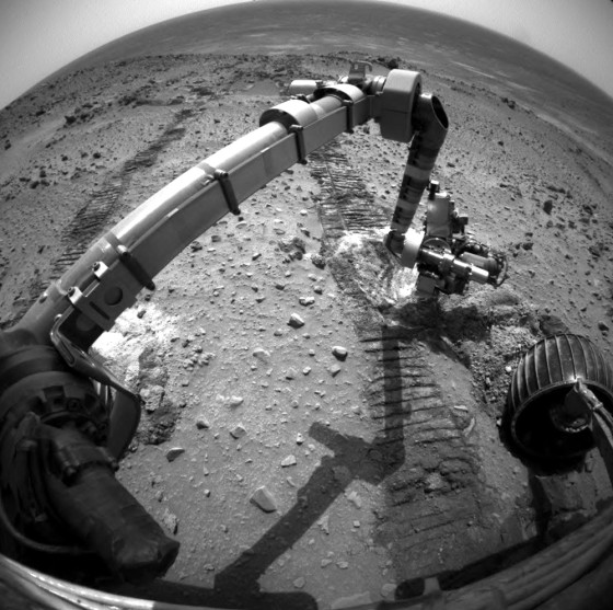 A wide-angle picture from the Spirit rover shows its own robotic arm poised over bright churned-up material in Gusev Crater — material that could represent a "Martian salt lick."