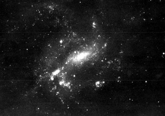 An optical photograph shows the galaxy NGC 4395, which has no central bulge but does contain a relatively runty supermassive black hole at its center.
