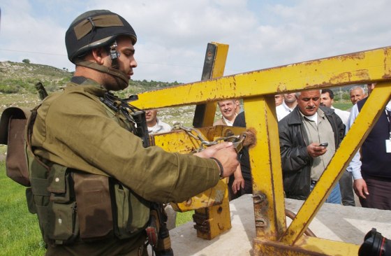 An Israeli army soldier opens the gate of Anabta in the outskirts of the West Bank town of Tulkarem, Tuesday.
