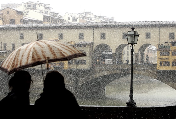 Florence, Italy, saw a light snowfall on Thursday, causing these folks across from the Ponte Vecchio bridge to use an umbrella.