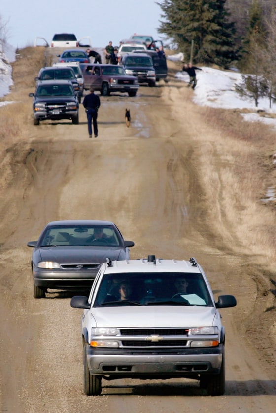 Police leave the property where four Alberta RCMP officers were shot dead during an investigation into a marijuana farm near the village of Rochfort Bridge, in northwestern Alberta, Canada, on Thursday.