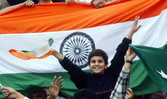 An Indian boy cheers for his cricket team during a test match in Mohali