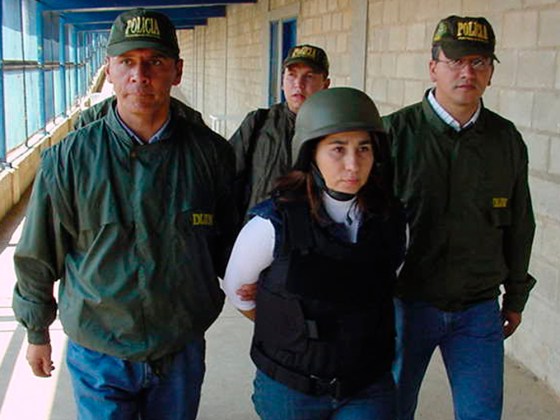 This photo released by Colombia's National Police shows police agents escorting guerrilla commander Omaira Rojas, known as Sonia, center, before she was flown Wednesday from a maximum security jail in northern Colombia to the United States.