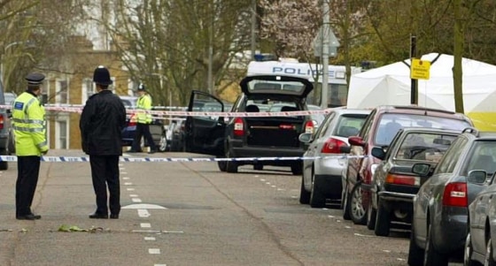 Police secure the scene Monday after an attacker thought to have used an ax to kill a man was arrested in this affluent part of north London.