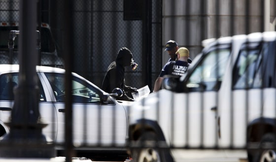 Emergency crews wear breathing devices Monday near the entry to a mail facility at the Pentagon. Hazmat crews responded to the facility after an alert went off for a possible hazardous material.
