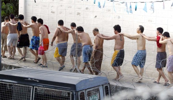 Philippine detainees form a human chain following the end of a stand-off with police inside Manila's Camp Bagong Diwa