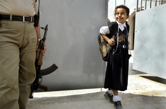 An Iraqi girl passes by an armed security guard as she leaves school in Baghdad in October.