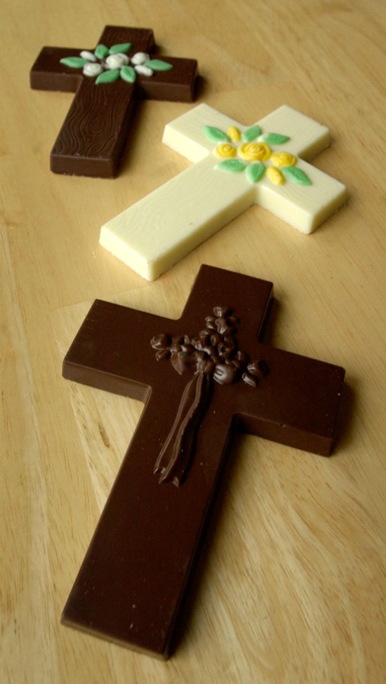 A caramel filled chocolate cross offered by Russell Stover's Pangburn Chocolate Company is seen in the foreground with solid white and milk chocolate crosses made by Palmer Company. With the introduction of its product, Russell Stover has joined the ranks of many smaller candy companies selling chocolate crosses this Easter season.