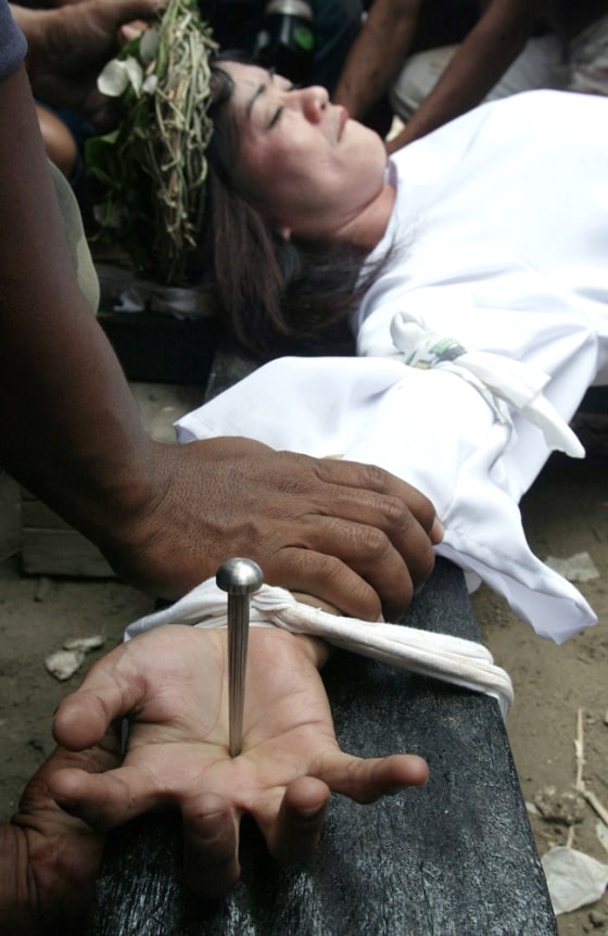 A Filipino penitent is nailed to a cross in her portrayal of Jesus Christ in the village of Saint Lucia on Good Friday