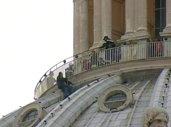 Video capture from Sky TG24 TV, showing a man holding on to the side of the St. Peter's Basilica dome after apparently climbing over the barrier meant to protect tourists Saturday.