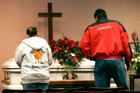 Mourners stand at the casket of Neva Rogers during a visitation service in Bemidji, Minn., Sunday.