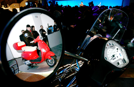 The Vespa LX, the new model is reflected on the rear view mirror of another one at a presentation ceremony in Rome