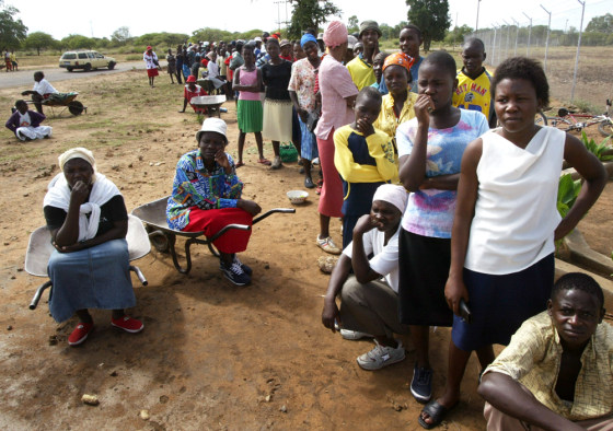 People wait for the government-owned grain depot to open so they can buy food in the small town of Tsholotsho, Zimbabwe, on Tuesday.