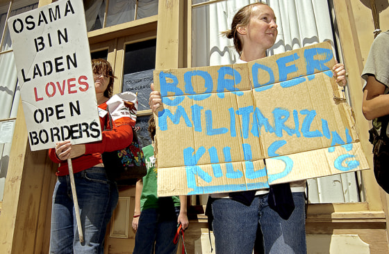 Deborah Shodler, left, of Mission Viejo, Calif. and Holly Hilburn of Tucson, Ariz. hold opposing views while demonstrating outside the registration hall of the Minuteman Project in Tombstone, Ariz. on March 31.