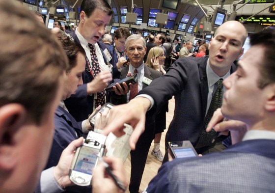 NYSE Specialist Chris Magarro, second right, trades shares of IBM on the floor of the New York Stock Exchange Friday. IBM’s disappointing earnings report contributed to a steep sell-off on Wall Street Friday.