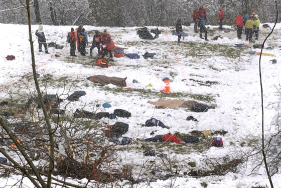 Rescuers stand above debris and the covered bodies of travelers who died in a bus accident on the road to the Great St. Bernard Pass between Orsieres and Liddes, Switzerland, Sunday.