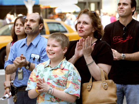 People applaud as they watch new Pope Benedict XVI on jumbo screen in Times Square