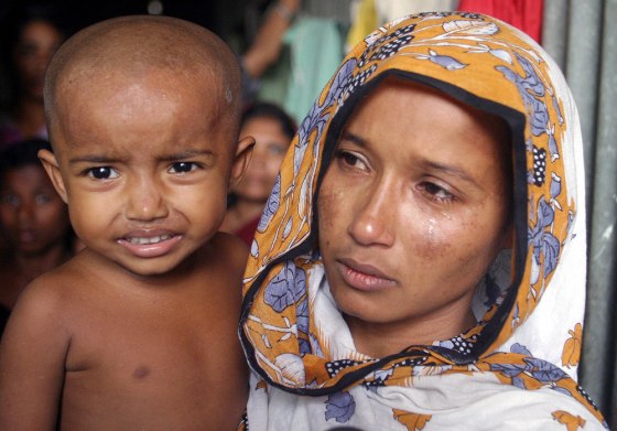 Shefali, a 26-year-old Bangladeshi woman, carries her daughter in Dhaka