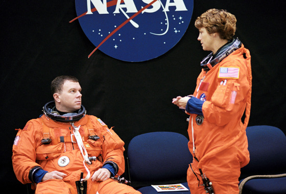 Astronauts James Kelly and Eileen Collins await the start of a training session in the Space Vehicle Mockup Facility at NASA's Johnson Space Center in Houston. Collins and Kelly are wearing training versions of the full-pressure launch and entry suit.