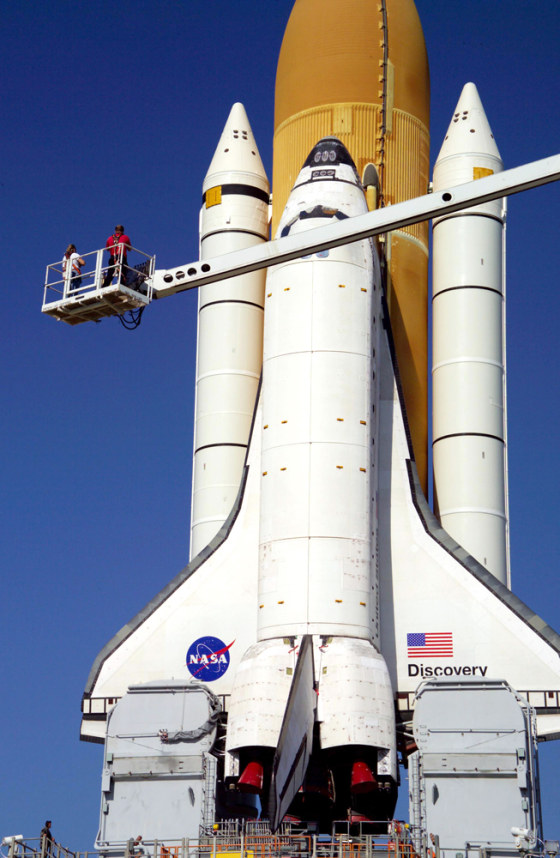 Technicians photograph the exterior of the shuttle Discovery during its April 6 journey to its Kennedy Space Center launch pad. The photo session was aimed at developing a database of imagery that can be compared with in-flight imagery, to check for potential damage.