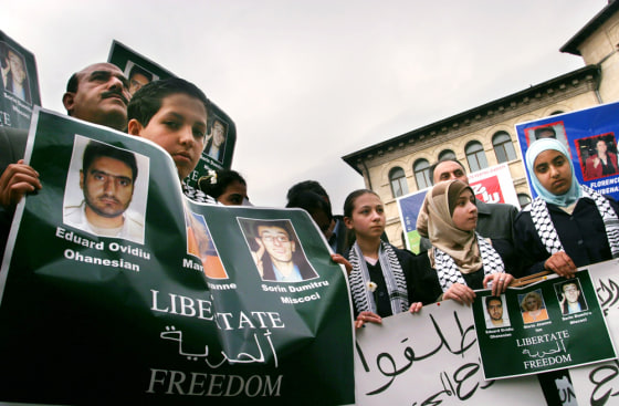 Children from the Arab community in Romania hold banners during a rally in Bucharest for kidnapped journalists in Iraq