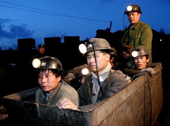 Chinese rescuers ride carts to search for the 30 trapped miners in a flooded mine in Jiaohe, northeast China's Jilin province