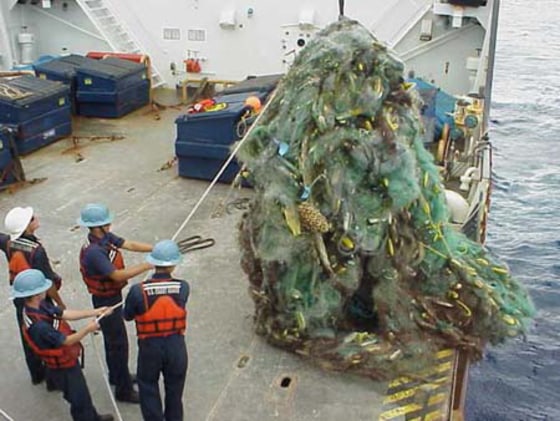 U.S. Coast Guard crew recover a derelict fishnet off Lisianski Island in northwest Hawaii. In that single operation, two Coast Guard ships removed 57,500 pounds of marine debris from coral reefs frequented by monk seals.