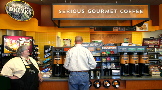 Mobil On the Run brew master Julie Gagne, left, stands by the ready as Jerry McGwinn of Portland, Maine, makes his coffee selection at the gourmet coffe island at a Manchester, New Hampshire Mobil station last month. Gourmet coffee and an employee assigned to them are part of a trend in convenience stores who are trying to be a one stop shop for people.