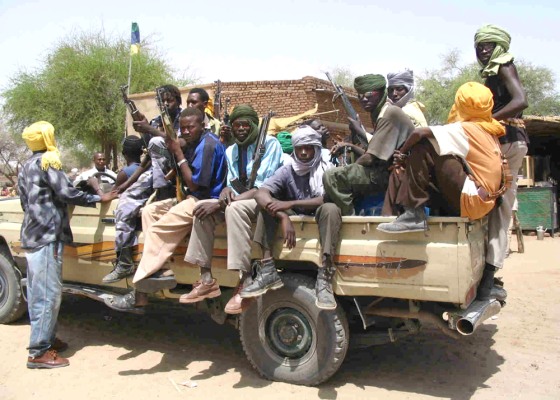 Sudanese Liberation Army rebels drive through town of Muhajara on a truck loaded with guns.