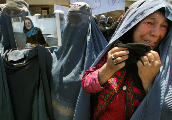 An Afghan widow cries as others hold up a photograph of Italian relief worker Clementina Cantoni during a protest against her kidnapping, at a CARE International food distribution center in Kabul, on Tuesday.