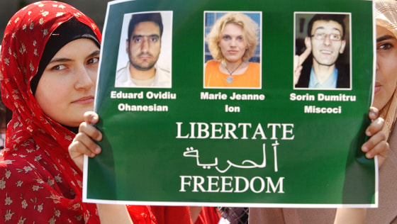 Women of the Romanian Arab community hold a poster showing the three Romanian journalists kidnapped in Iraq, during a protest held in Bucharest, Romania in April.