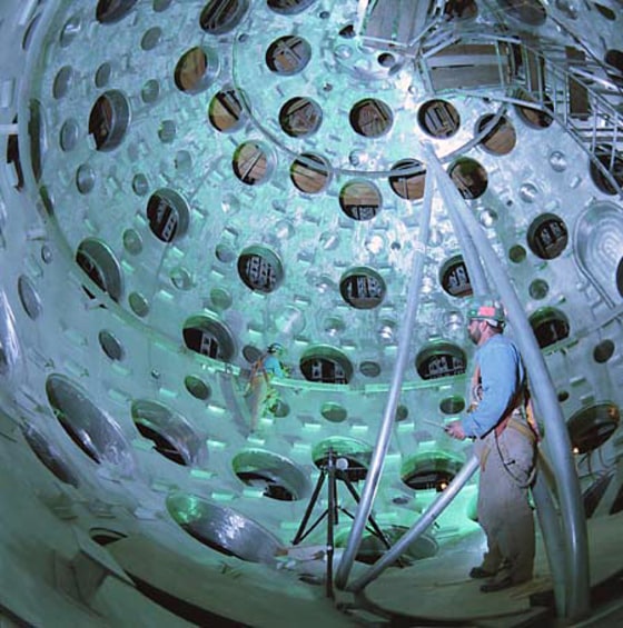 Workers stand within the chamber of the National Ignition Facility, which measures 30 feet (9 meters) in diameter.