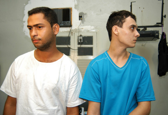 Suspects Ronald Ribeiro Rodrigues, 22, left, and Mayderson Vargas Mendes, 21, seen at a police station, in Guarapari, Brazil, said that they bound, drugged, and killed three people as part of a game.