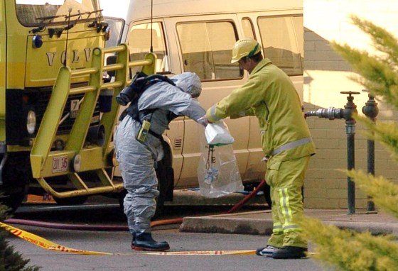 A special hazardous chemical expert removes a package from the Indonesian embassy in Canberra