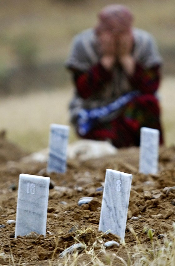 A woman cries near numbered plaques allegedly marking fresh anonymous graves of crackdown victims in a cemetery on the outskirts of Andijan, Uzbekistan, in this May 19 file photo.