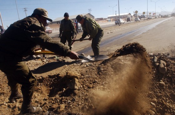Boivian police use shovels to clear a blocked road in El Alto, Bolivia, on Saturday. Weeks of protests demanding the nationalization of the oil industry paralyzed much of Bolivia and doomed President Carlos Mesa.