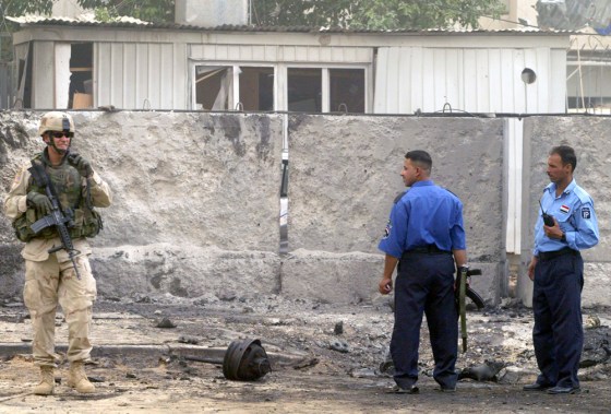 A US soldier and Iraqi police secure the