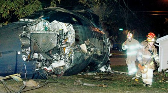 Firefighters inspect the scene of a jet crash in Jefferson City, Mo., on Oct. 14, 2004. Two pilots decided to experiment while they were ferrying the 50-seat commuter jet and took it to an unusually high altitude. Both died after the engines failed and the plane crashed.