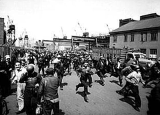 Workmen at Baltimore's Bethlehem-Fairfield shipyards run to punch the clock at the end of their shift in May 1943.