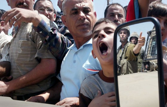 Palestinians shout at Israeli soldiers d