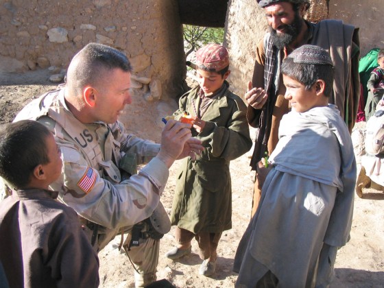 Lt. Col. Mark Stammer passes out stuffed animals and pencils to children in Badamtoy, part of an effort to win the support of local populations in areas where the Taliban operates.