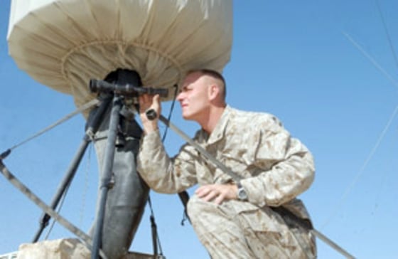 Marine Cpl. Wesley S. Fomin checking to make sure the counter mortar radar at his base camp in Iraq is sighted properly to maintain its accuracy.