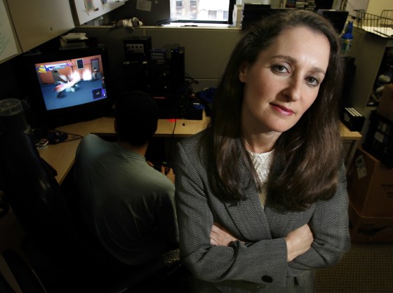 Patricia Vance, president of the Entertainment Software Rating Board, poses for a photo as a tester plays a game at the board's headquarters in New York.