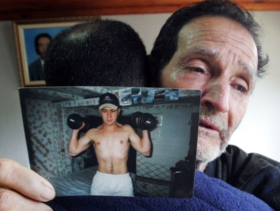 Matuzinho Otone is comforted by an unidentified relative as he holds a picture of his son Jean Charles de Menezes at their home near Gonzaga, Brazil, Sunday.