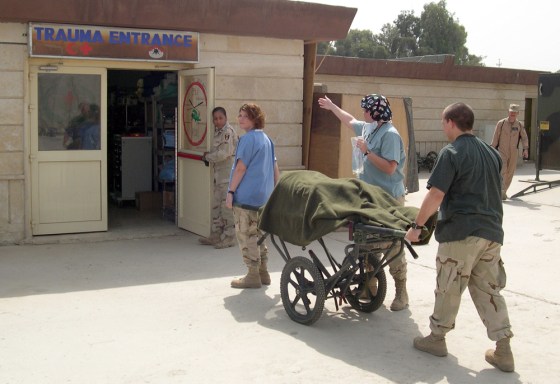 Dr. Tamarin McCartin, in blue scrubs, directing a patient into the emergency room of the U.S. Army’s 228 Combat Support Hospital in Mosul earlier this month. 