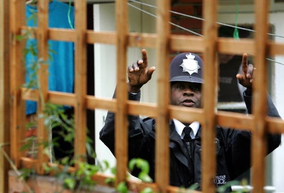 A police officer gestures at the rear of