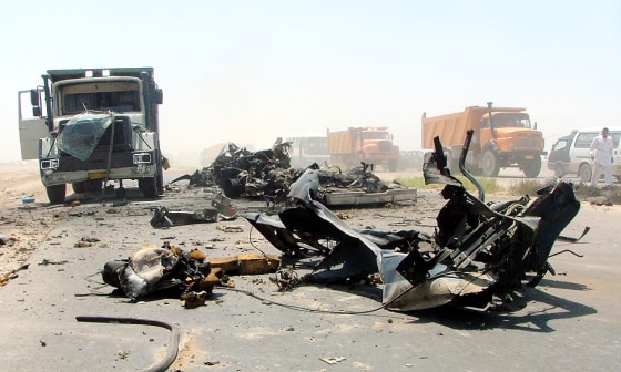 The wreckage of Iraqi police patrol vehicles litters the highway in Baghdad on Sunday. The vehicles were destroyed by a deadly car bomb earlier in the day.